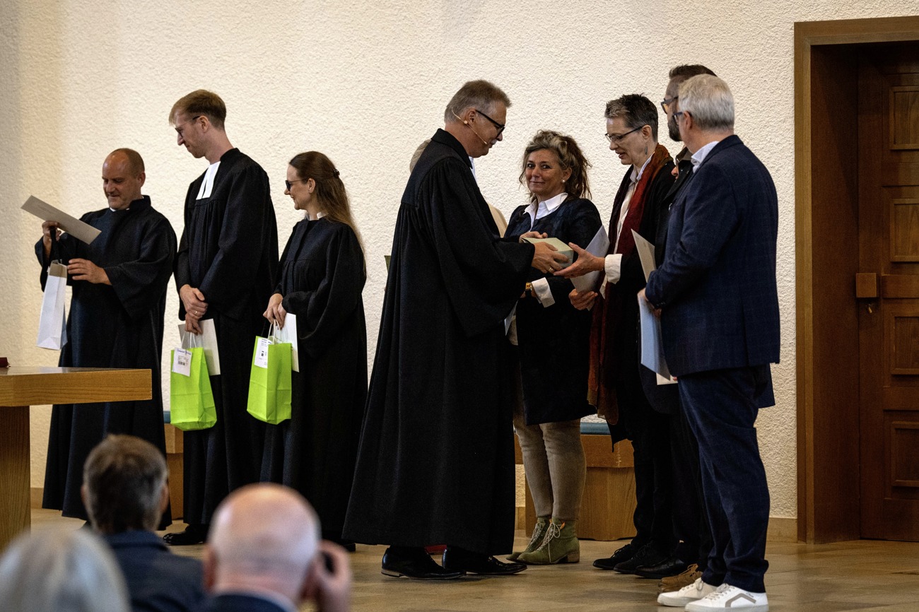 Kirchenratspräsident Martin Schmidt überreicht Präsente. Foto: kid/ack